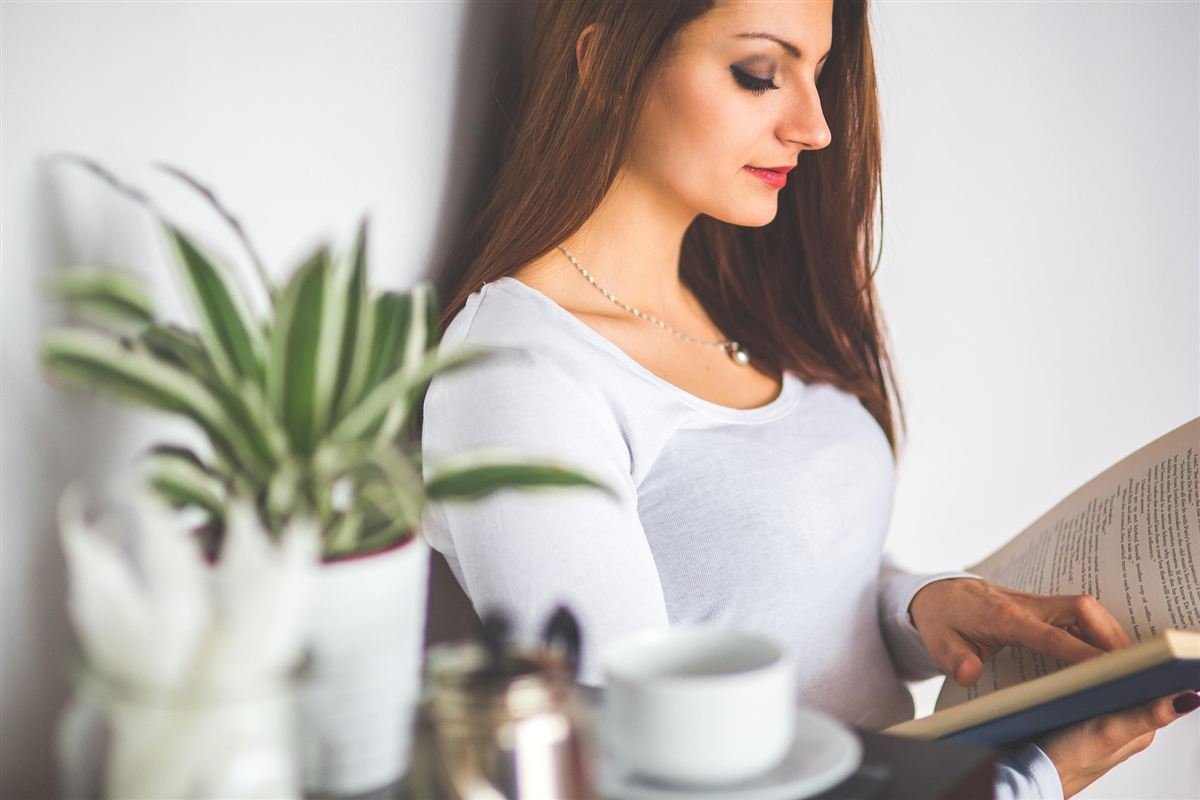 Mujer leyendo junto a plantas